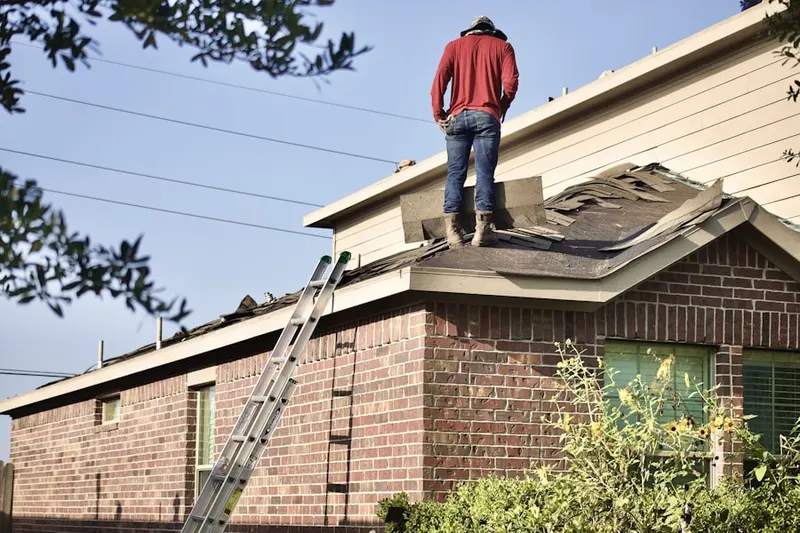 Professional roofer working on a residential roof in Lake Milton